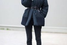 a casual winter look with black jeans, lace up booties, a black sweater and a plaid puffer coat with a leather belt