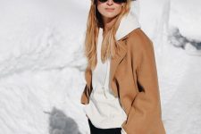 a chic outfit with a white cashmere hoodie, black skinnies, a tan coat and a tan hat