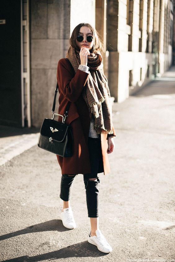 a cognac coat, a plaid neutral oversized scarf, white sneakers and a black bag for a chic look
