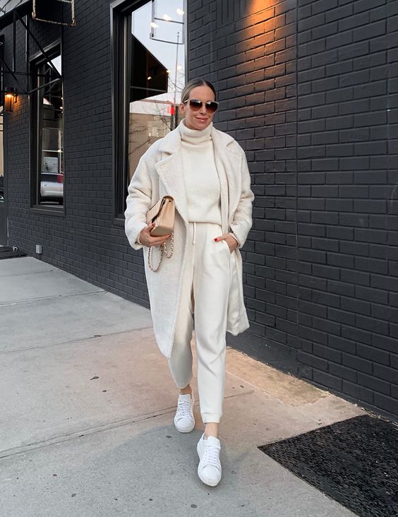 a comfortable everyday look with a white sweater, white joggers, sneakers, a fau fur coat and a tan bag