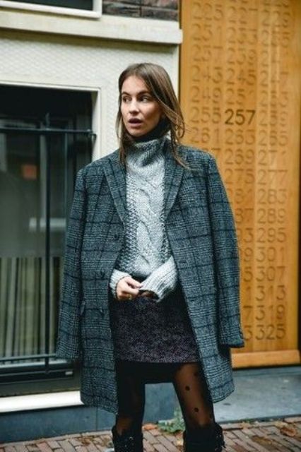 a cozy winter outfit with a grey braided sweater, a dark grey mini skirt, a grey plaid coat, tall black boots