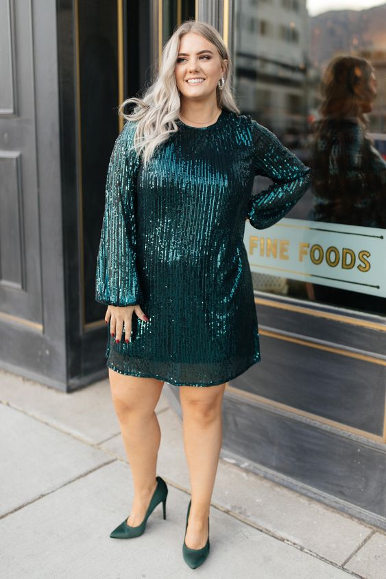a dark gree shiny holiday dress with long sleeves and matching dark green shoes are all you need to make a statement