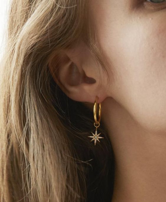 a gold hoop earring with a large embellished star is an ultimate idea to go for and it looks amazing