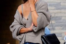 a grey knit cardigan and a matching crop top, blue jeans and a black bag make up a cozy and comfy look