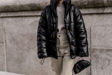a grey sweater, neutral cargo pants, black Chelsea boots, a black bag and a black leather puffer jacket