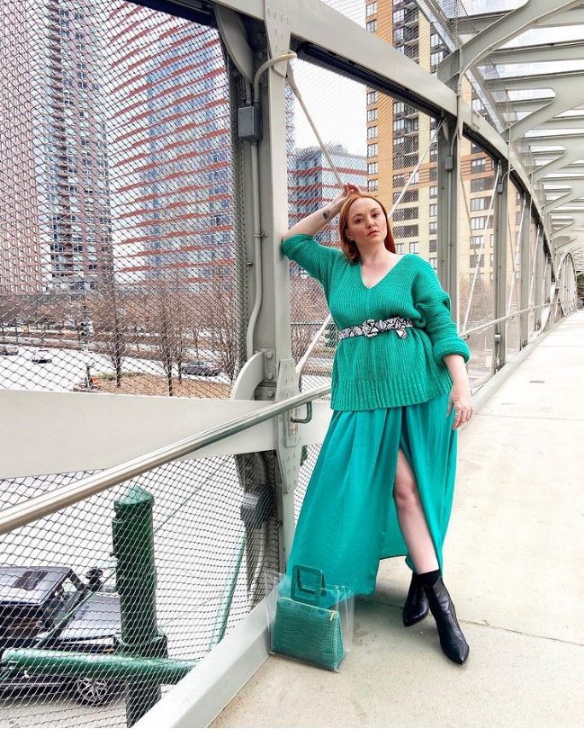 a jaw-dropping outfit with an emerald sweater, a turquoise midi skirt, black boots and a catchy turquoise bag