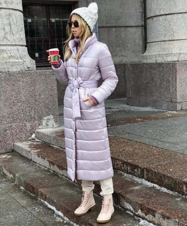 a lovely pastel look with white pants, blush boots, a lilac puffer coat with a belt and a white beanie