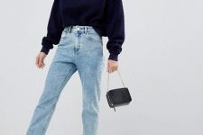 a navy zip sweater, light blue jeans, grey trainers, a small black bag for a fall or winter look