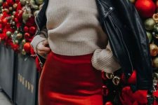 a neutral sweater, a red velvet midi skirt with a slit and a black leather jacket for a bold and hot look