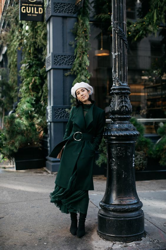 a refined look with a dark green midi dress and a matching coat, dark green velvet boots and a white beret