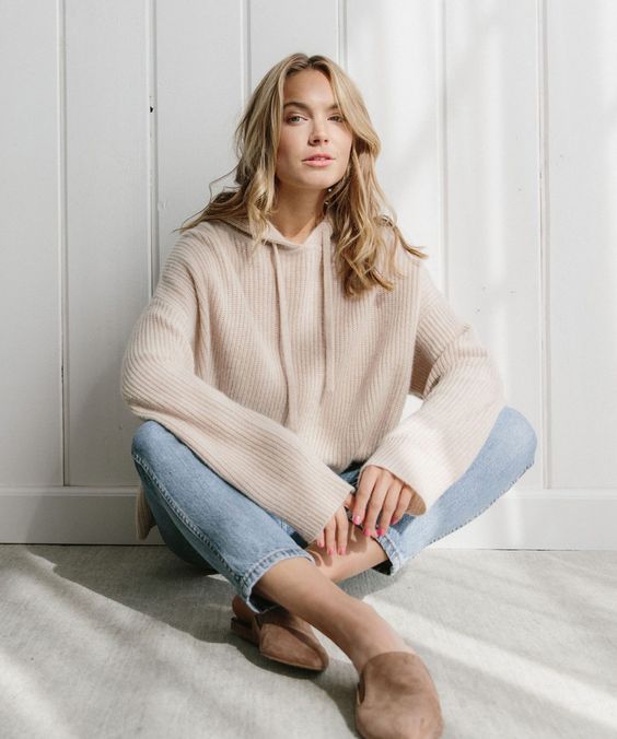 a relaxed and girlish outfit with a blush cashmere hoodie, light blue jeans, taupe mules is ideal
