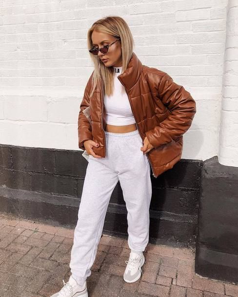 a simple look with a white crop top, joggers, an amber leather puffer jacket and white trainers for every day