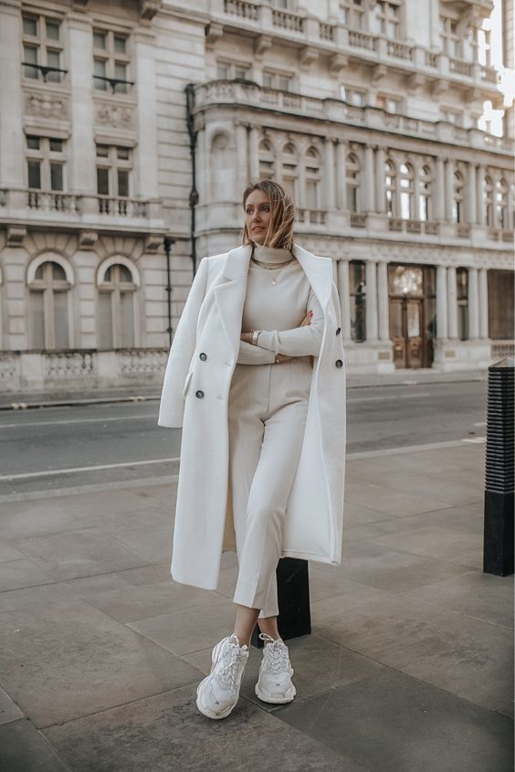 a simple winter outfit with white pants, an ivory turtleneck, white trainers and a creamy coat is very elegant