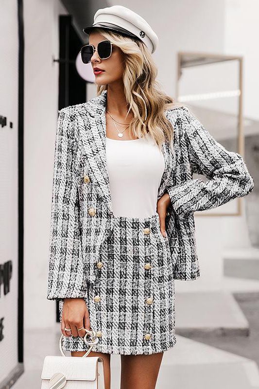 a skirt suit with a blazer and a mini, gold buttons, a white bag, cap and a top plus layered necklaces for a catchy work look