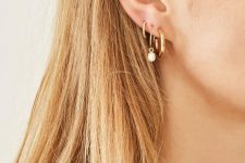 a statement gold hoop, a gold hoop with a pearl and an embellished hoop mini earring