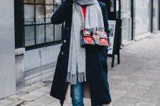 a stylish outfit with a red top, blue jeans, lacquer boots, a black coat and a grey scarf plus a printed bag