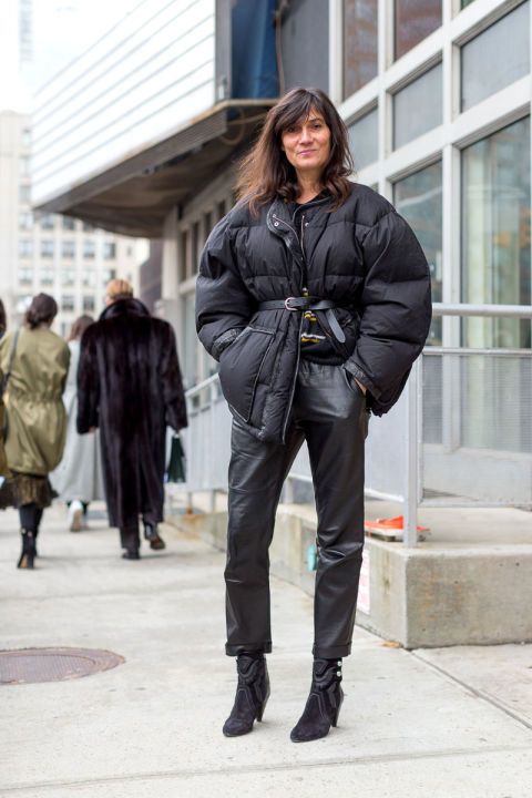 a total black look with a hoodie, leather pants, booties, an oversized short puffer jacket with a leather belt