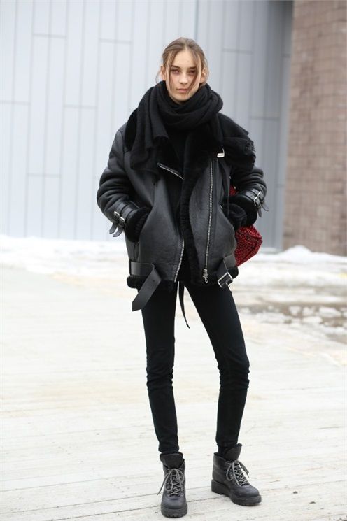 a total black look with skinnies, boots, a sweater, an oversized scarf, a shearling coat and a burgundy bag
