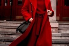 a total red look with a sweater, pants, sock boots, a midi coat and a black bag plus a deep burgundy lip