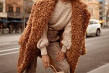 a white sweater, plaid neutral pants, a brown fuzzy faux fur coat and a tan bag for winter