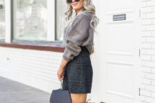 an oversized chunky knit grey sweater, a teal tweed mini skirt, grey suede tall boots and a black bag