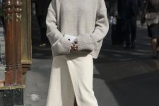 an oversized grey turtleneck sweater, an ivory wrap midi skirt, tan shoes and a white clutch for a minimalist look
