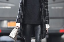black leather leggings, a sweater, a puffer coat, flat boots and a grey bag for winter
