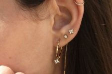embellished studs, a tiny hoop earring in helix and a gold hoop earring with an embellished pendant star