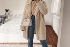 grey trainers, light blue jeans, a cropped tan sweater, a creamy faux fur coat and a creamy bag