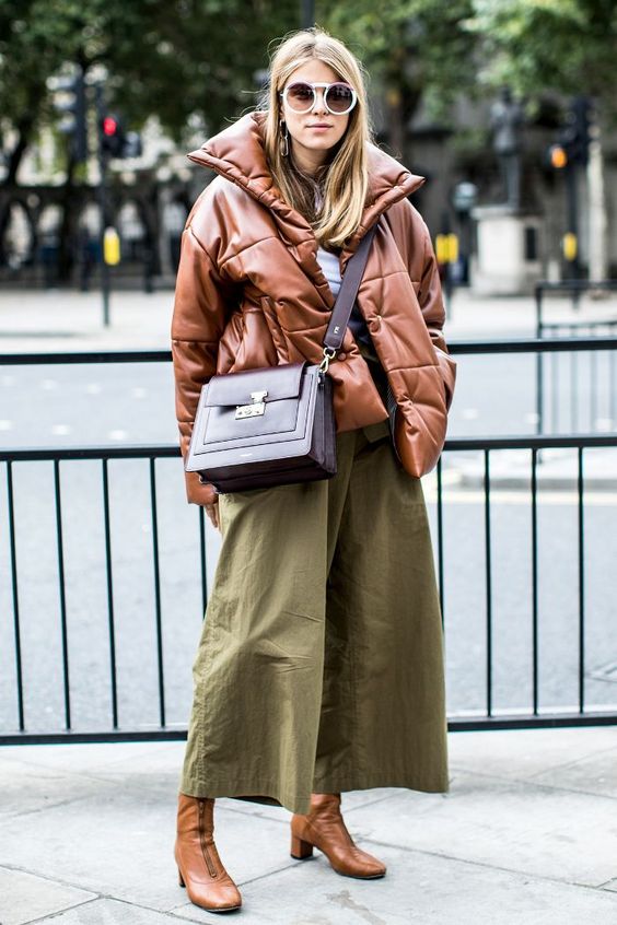 olive green wideleg pants, brown boots, a brown leather puffer jacket and a burgundy bag for fall or winter