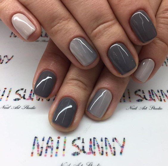 a chic glossy monochromatic manicure in various shades of grey and nude is very stylish