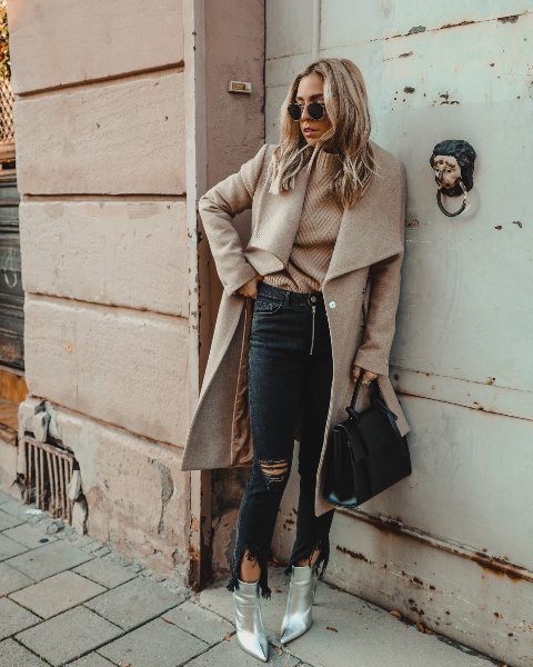 With beige sweater, distressed jeans, black bag and beige midi coat