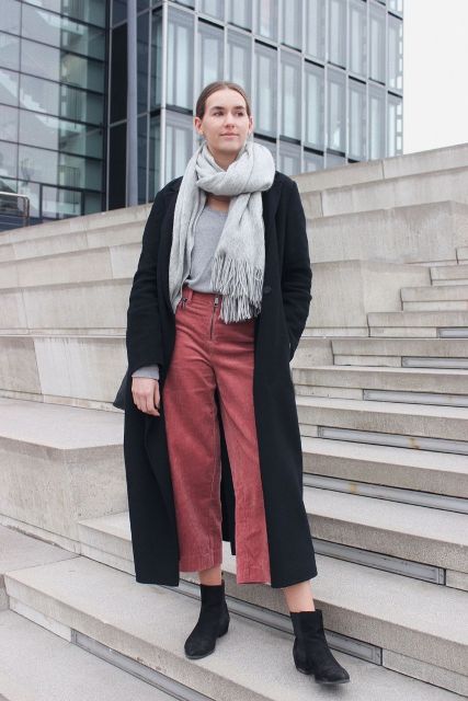 With gray t-shirt, gray fringe scarf, black midi coat and black flat boots