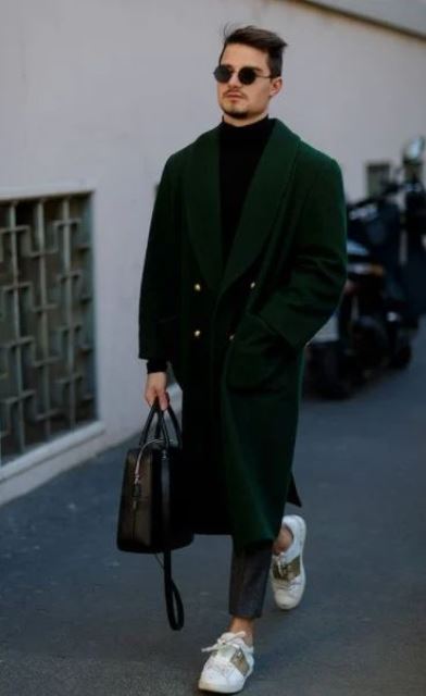 a black turtleneck, navy jeans, color block sneakers, a hunter green midi coat and a black bag for a statement