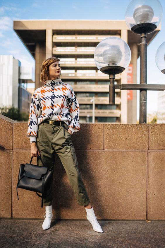 a bright printed sweater, olive green pants, white ankle boots and a black bag for a bold work look