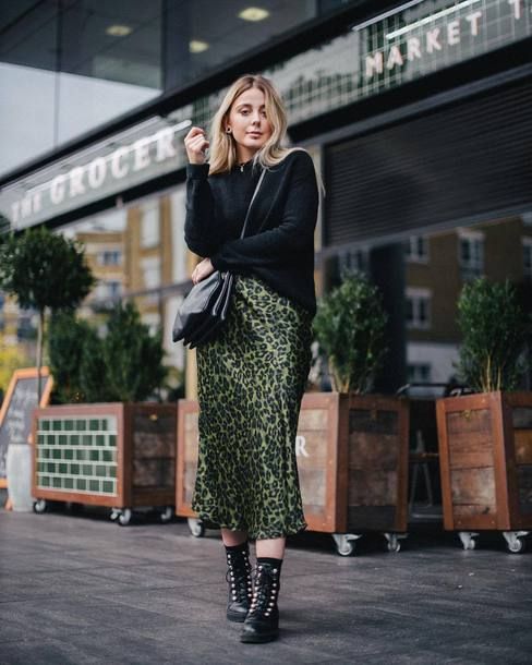 a creative look with a black sweater, a green leopard print midi skirt, black combat boots and a black bag