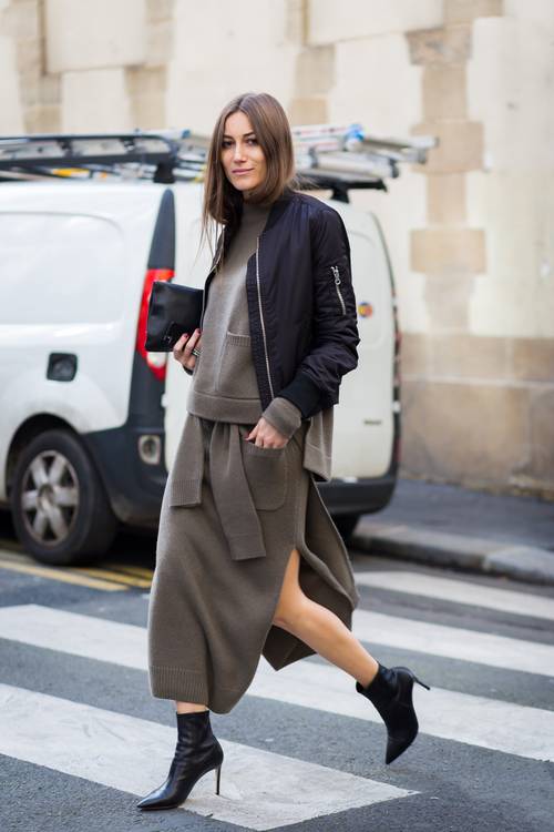 a knit sweater with pockets and a matching midi skirt, black booties, a black clutch and bomber jacket