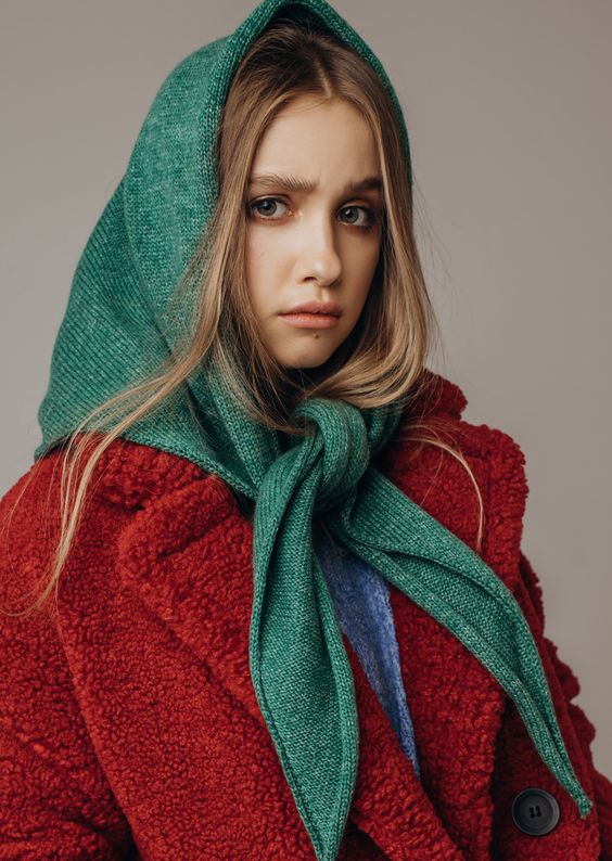 a red faux fur coat paired with a green woolen headscarf are ideal for composing a Christmas look