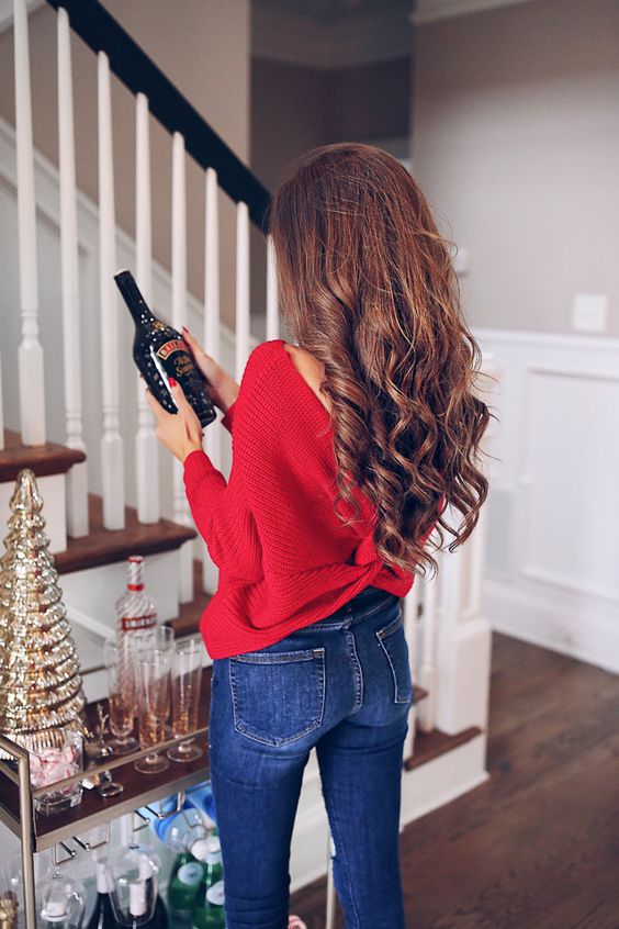 a red wrap sweater with an open back and blue skinnies are all you need for a gorgeous holiday look