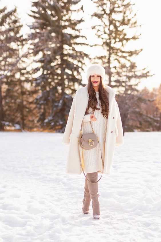a white sweater dress, grey suede boots, a grey bag, a white faux fur coat and a fur hat