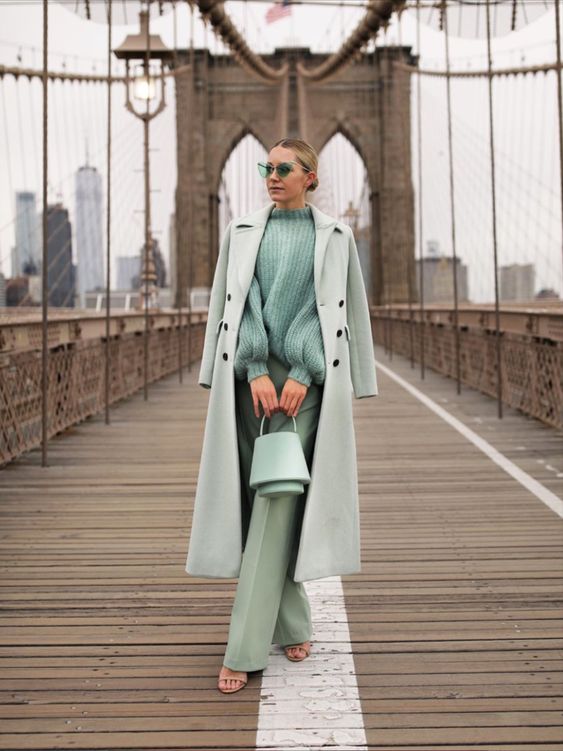 a beautiful pastel green look with an oversized sweater, trousers, a midi coat, a bucket bag and glasses