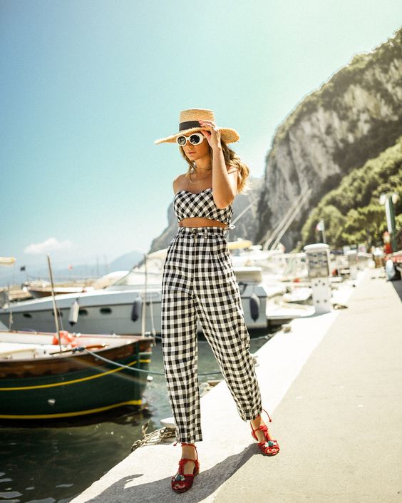 a buffalo check summer suit with a crop top and pants, red shoes and a hat for a holiday