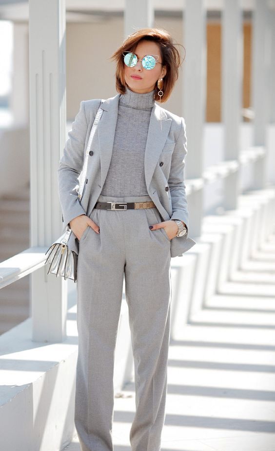 a light grey suit, a matching turtleneck, a silver crossbody bag and black and white shoes