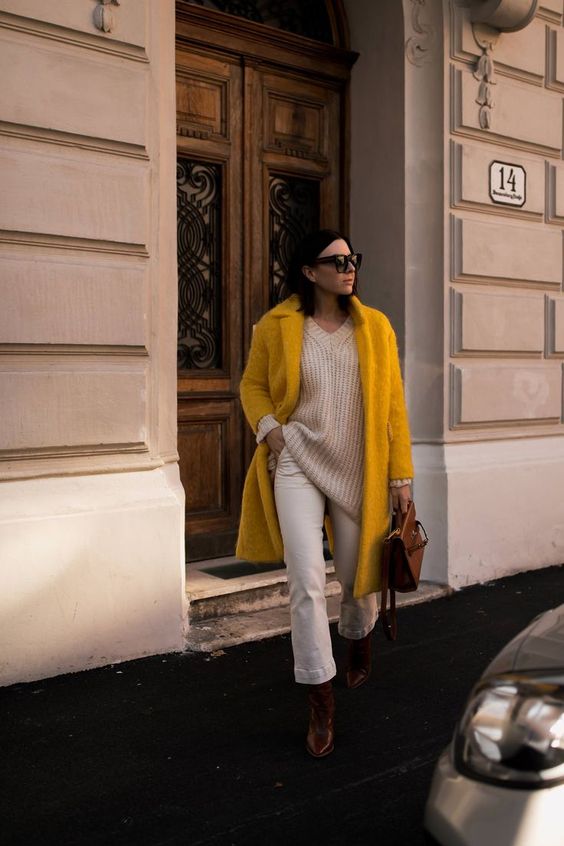 a white chunky sweater, white jeans, burgundy boots, a yellow fuzzy coat and a brown bag
