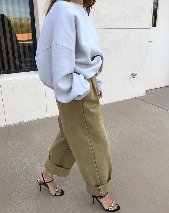an oversized grey sweatshirt, green barrel jeans, embellished heels for a chic and comfortable look