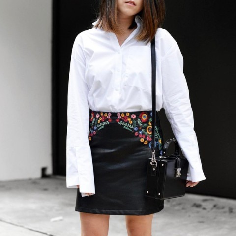 With white loose button down shirt and black leather bag