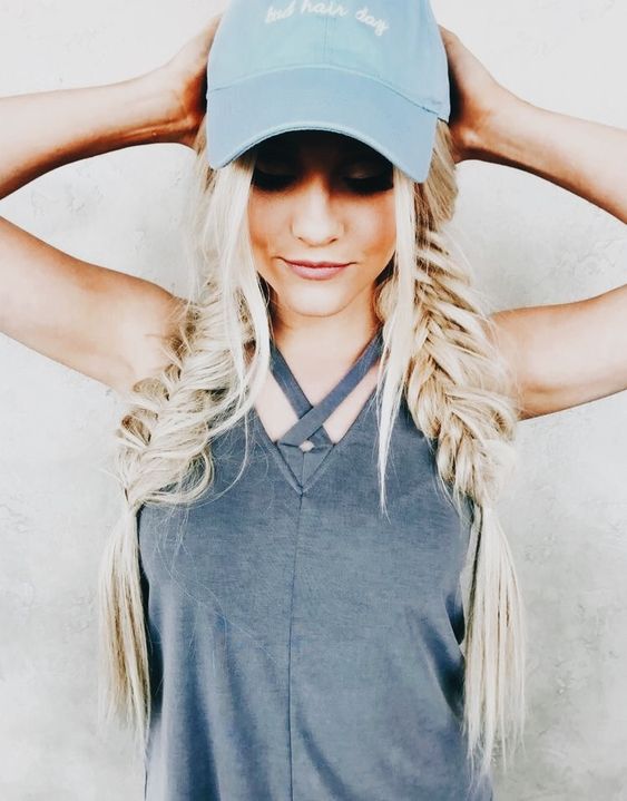 a baseball hat paired with two Dutch braids and some hair down is always a good idea