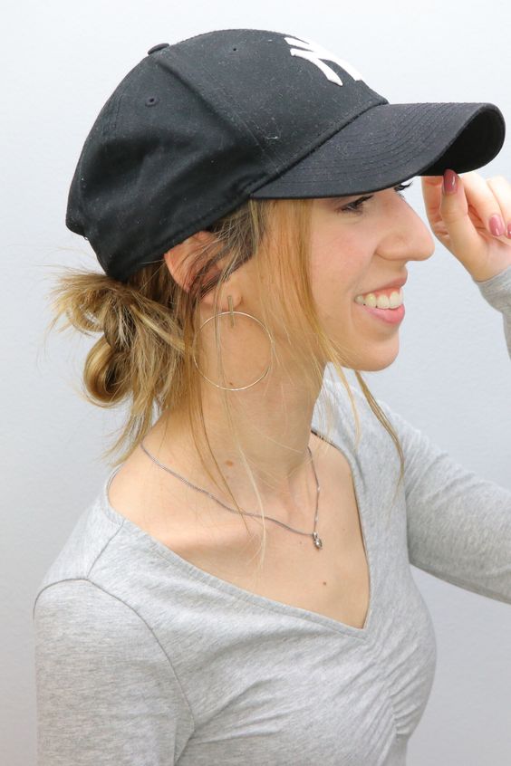 a black baseball cap and a messy low side bun and hair down are a lovely combo for an every day look