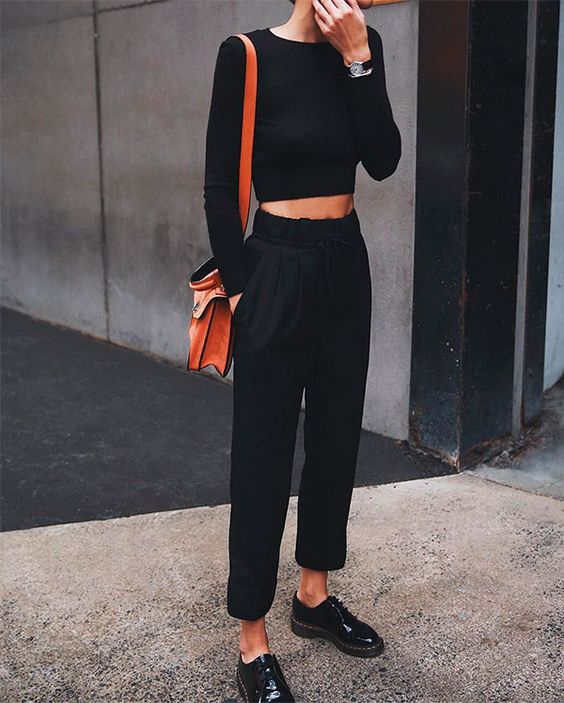 a black long sleeve crop top, joggers, black Derby shoes and an orange bag for a casual and comfy look