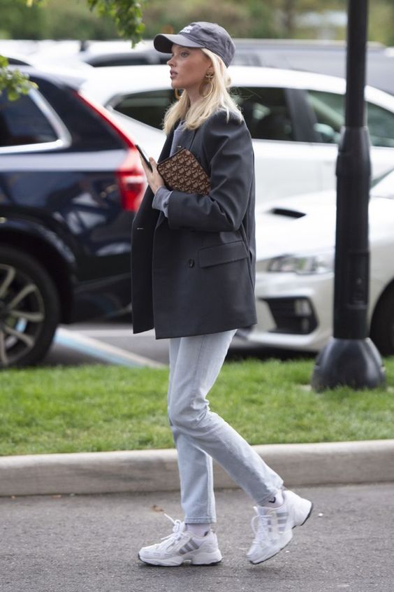 a comfy look with an oversized black blazer, white jeans, white trainers, a clutch and a black baseball hat